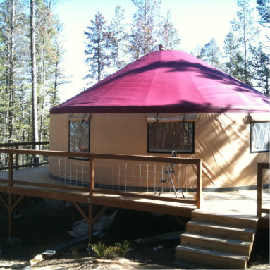 tan shelter designs yurt with a red roof