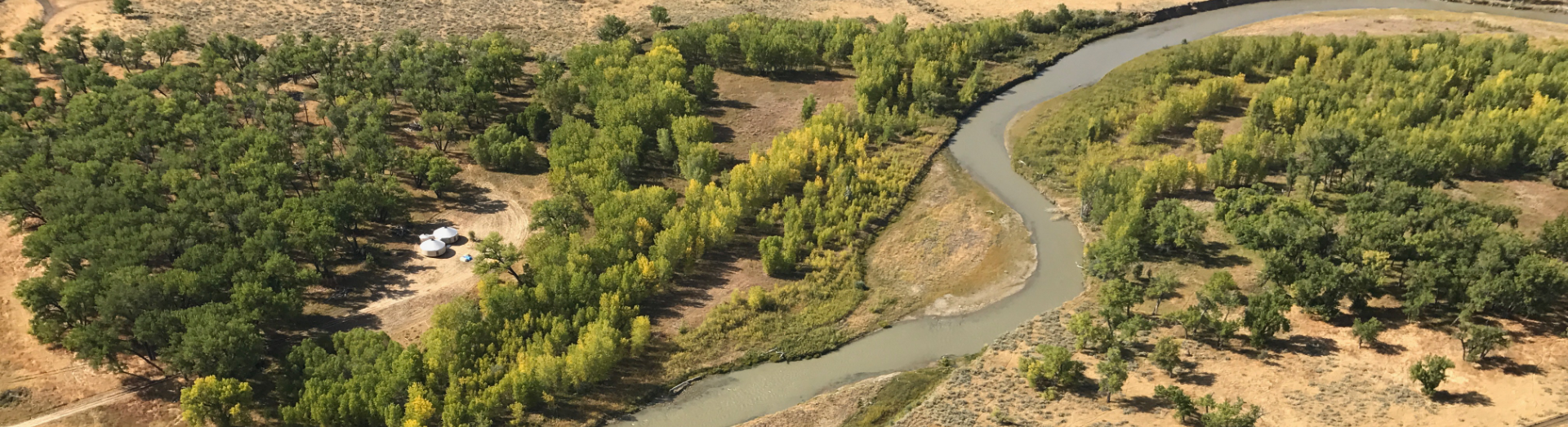 birds eye view of two yurts by a river