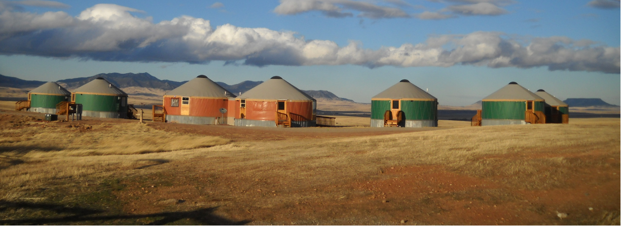 5 green and 2 orange yurts in montana