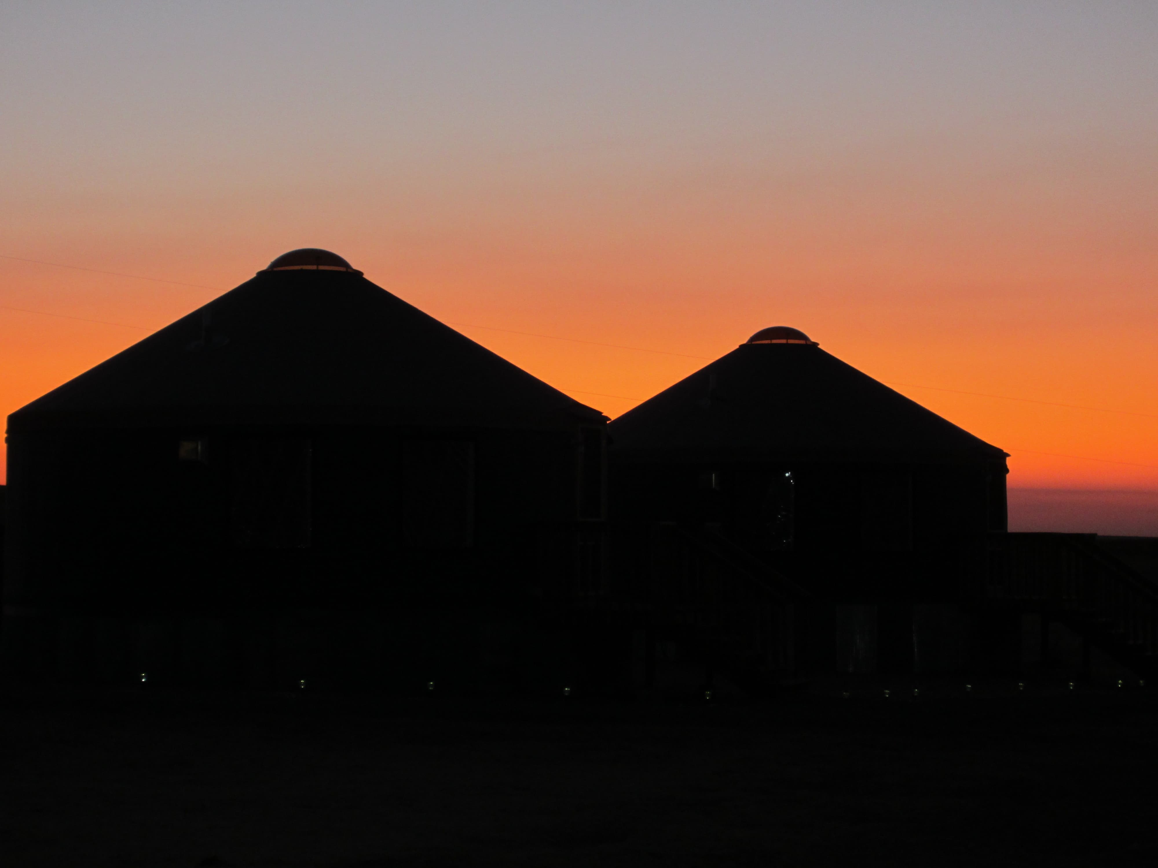 two shelter designs yurts with a sunset