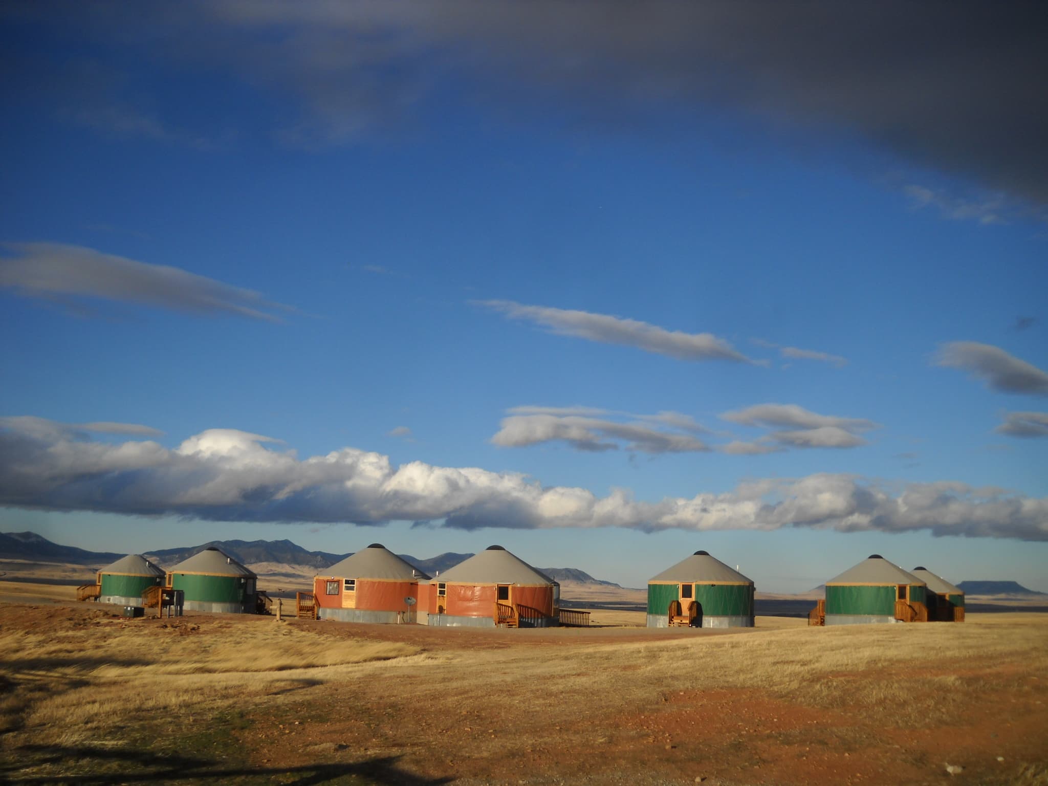 5 green and 2 orange yurts in montana