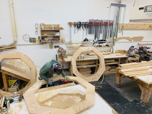 man in shop working on yurts