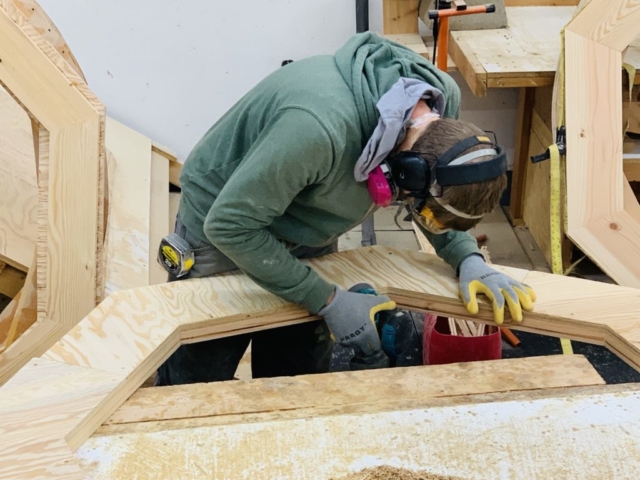 a man working on a shelter designs yurt center ring